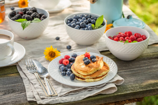 A plate of pancakes with berries on top.