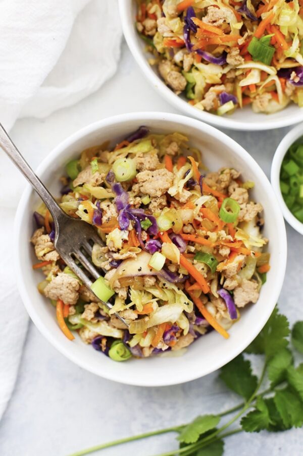 A bowl of food with broccoli and carrots.