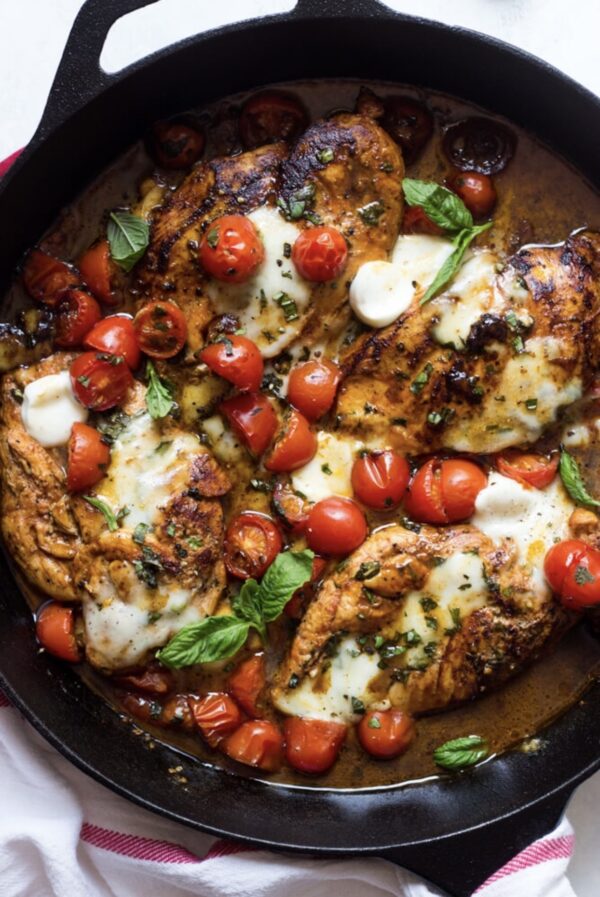 A pan of food with some chicken and tomatoes