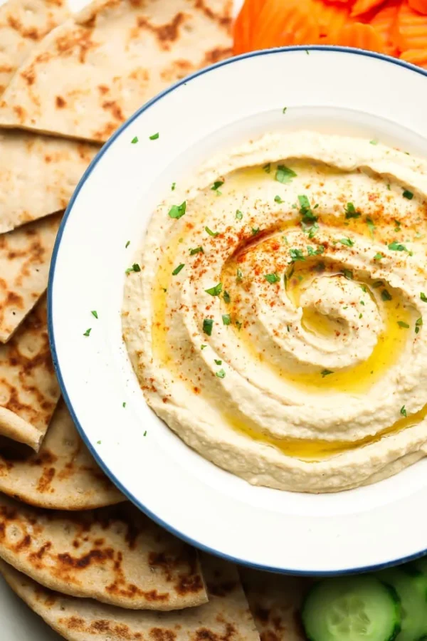 A plate of hummus and pita bread on the side.