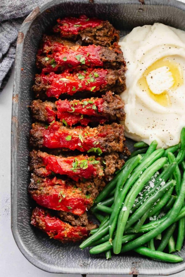 A plate of meat and vegetables with sauce.