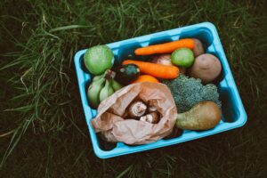 A blue container filled with fruits and vegetables.