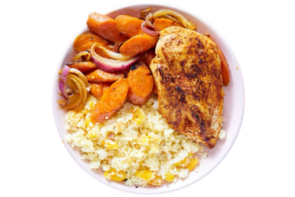 A bowl of rice, chicken and vegetables.
