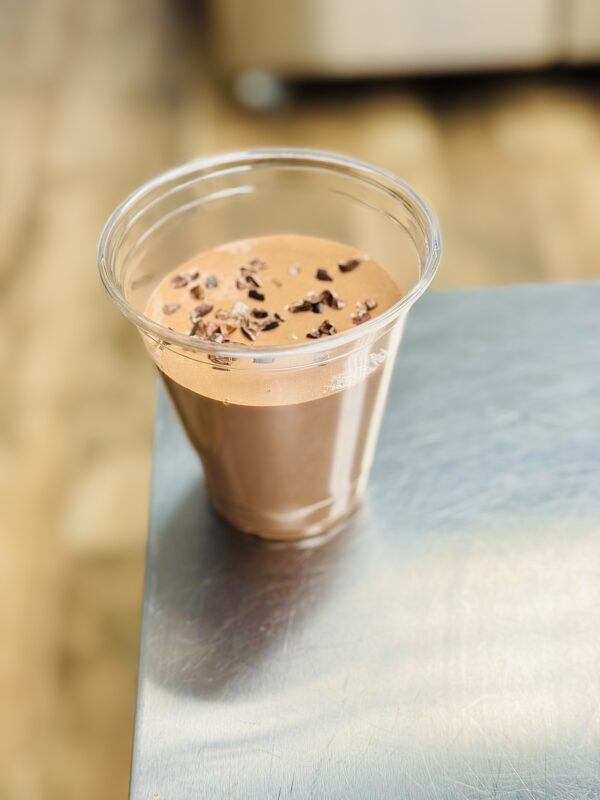 A cup of chocolate milk on top of a table.