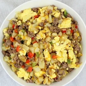 A bowl of food with meat and vegetables.