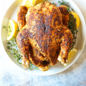 A plate of food with chicken and lemon.