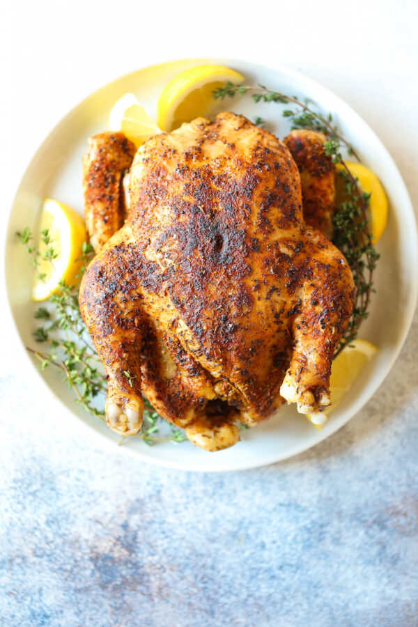 A plate of food with chicken and lemon.