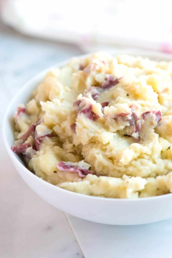 A bowl of mashed potatoes with bacon in it.