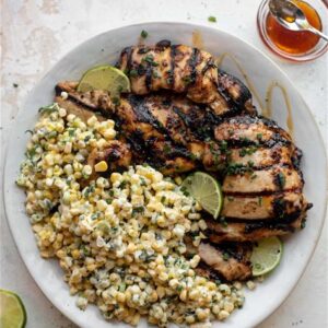 A plate of food with corn and chicken.